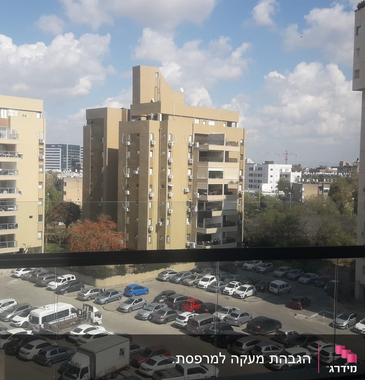 מעקה זכוכית במרפסת עם נוף לעיר